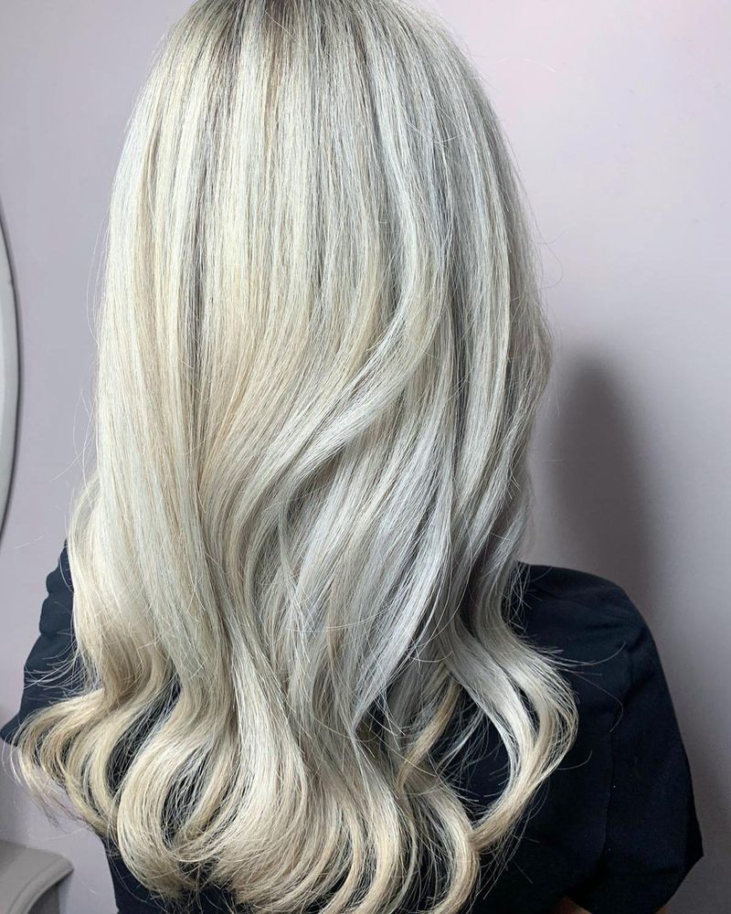 Woman with long, curled blonde hair after Olaplex in-salon treatment